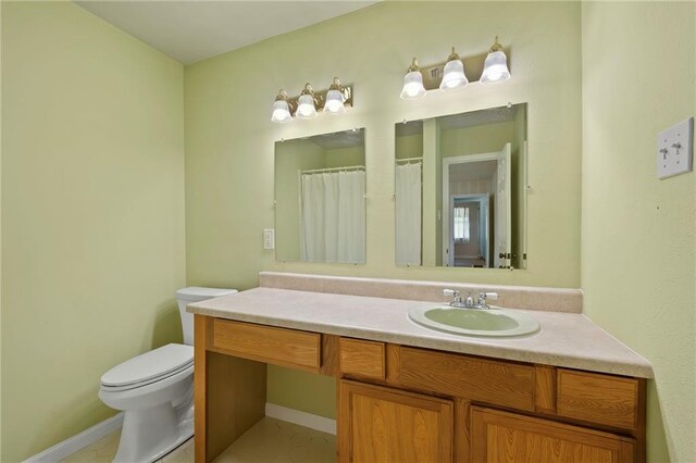 bathroom featuring toilet, tile patterned floors, and vanity