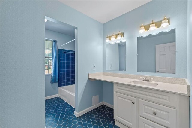 bathroom with tile patterned floors, vanity, and tiled shower / bath