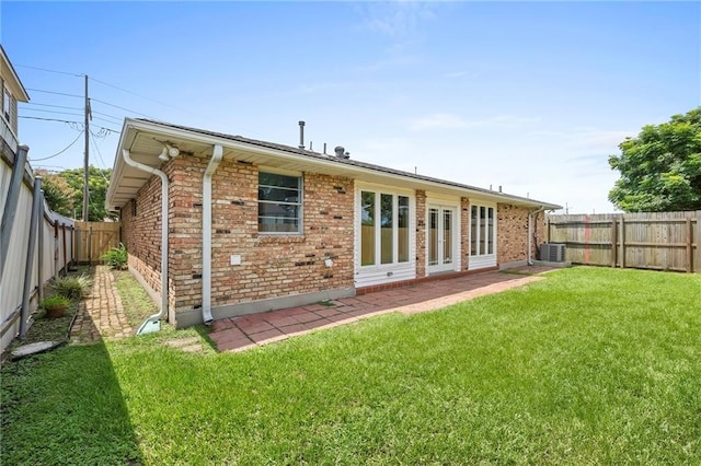 back of property with central AC unit and a lawn