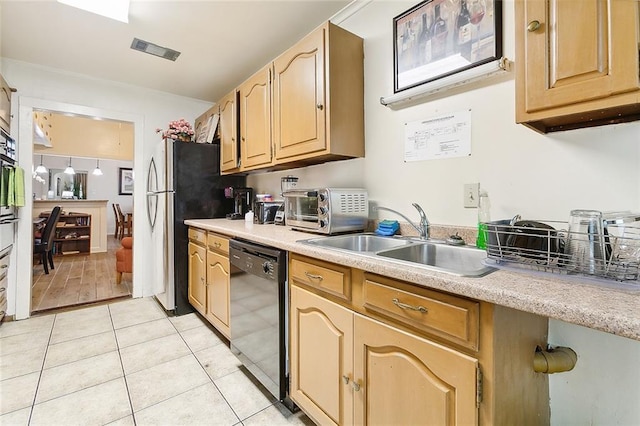 kitchen with light brown cabinetry, black dishwasher, sink, stainless steel fridge, and light tile patterned floors