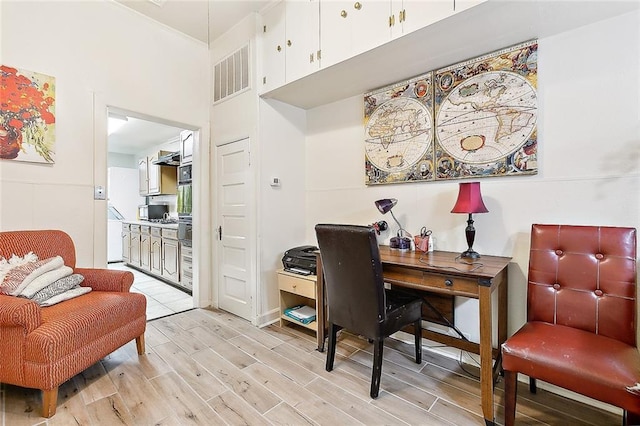 office area with ornamental molding and light hardwood / wood-style flooring