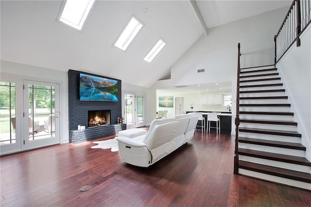 living room featuring beam ceiling, a skylight, high vaulted ceiling, dark hardwood / wood-style floors, and a fireplace