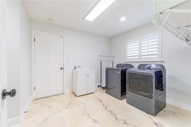 laundry room featuring cabinets, independent washer and dryer, and sink