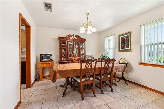 tiled dining area with a chandelier