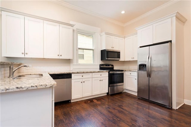 kitchen with sink, light stone counters, ornamental molding, stainless steel appliances, and white cabinets