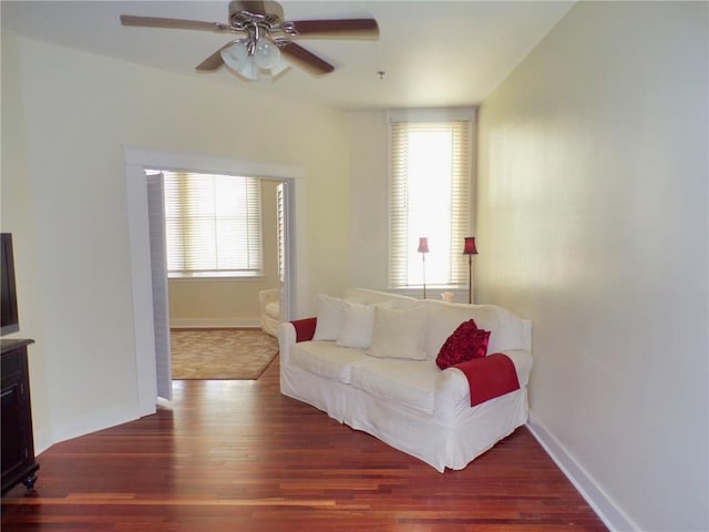 sitting room featuring dark wood-type flooring and ceiling fan