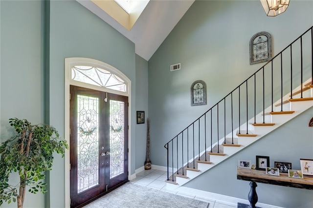 tiled entryway featuring french doors and high vaulted ceiling