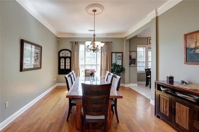 dining space with a healthy amount of sunlight, ornamental molding, and light hardwood / wood-style flooring