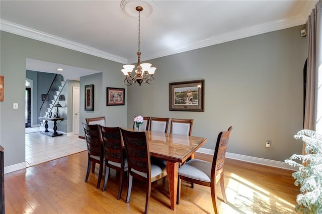 dining room featuring crown molding, a notable chandelier, and light wood-type flooring