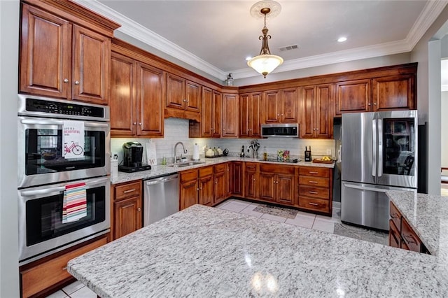 kitchen with sink, pendant lighting, crown molding, and stainless steel appliances