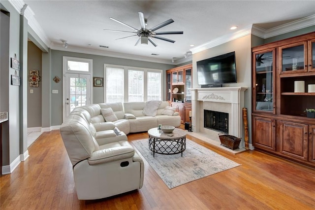 living room with crown molding, light wood-type flooring, and ceiling fan