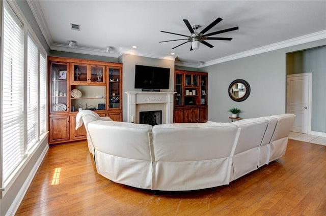 living room featuring crown molding, light wood-type flooring, and ceiling fan