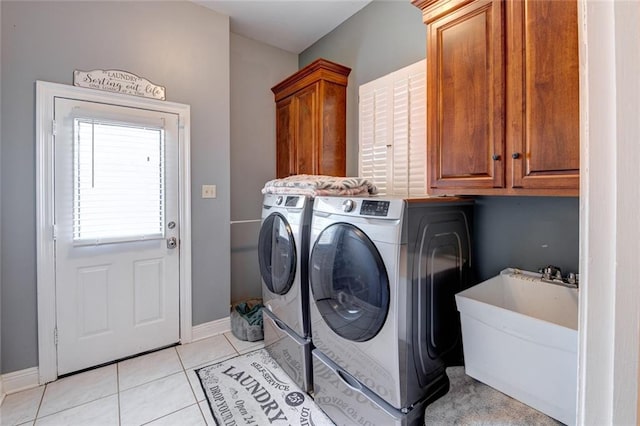 laundry area featuring cabinets, independent washer and dryer, sink, and light tile patterned floors