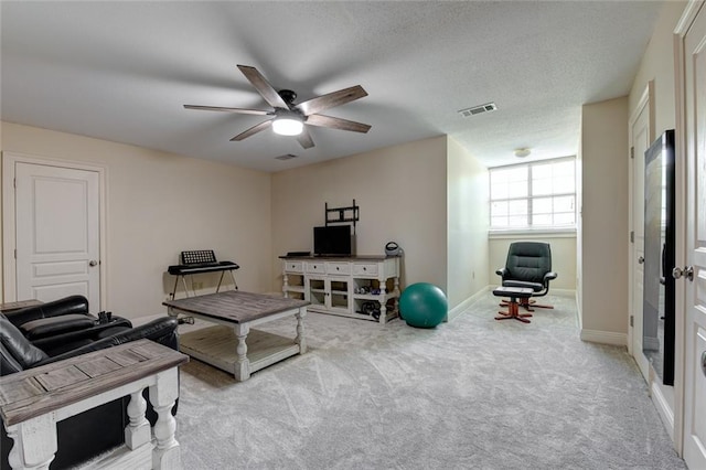 living room with a textured ceiling, light colored carpet, and ceiling fan