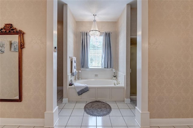 bathroom featuring an inviting chandelier, tile patterned flooring, and a washtub