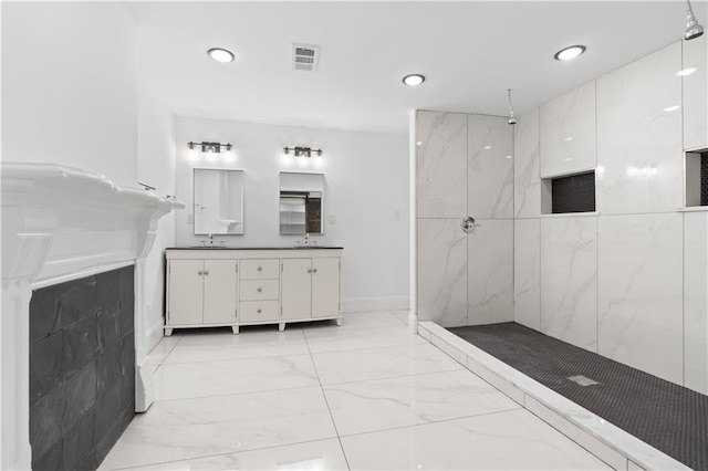bathroom featuring tiled shower and vanity