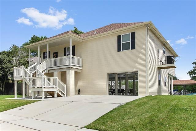 view of front of property featuring covered porch, stairway, and a front yard