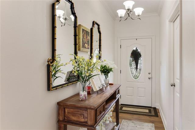 doorway to outside featuring a chandelier, wood-type flooring, and ornamental molding