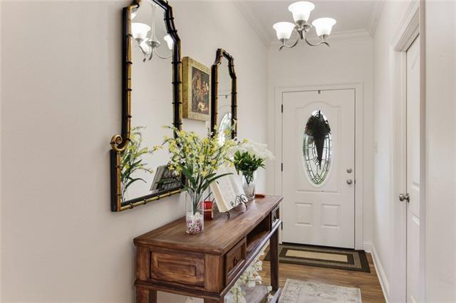 doorway with a chandelier, ornamental molding, and wood finished floors