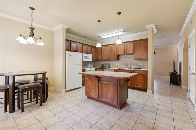 kitchen featuring crown molding, white appliances, backsplash, a center island, and decorative light fixtures