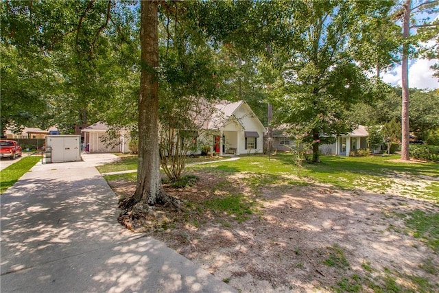 view of property hidden behind natural elements with a front lawn