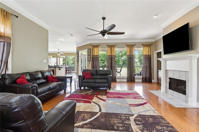 living room with hardwood / wood-style floors, ceiling fan, a wealth of natural light, and crown molding