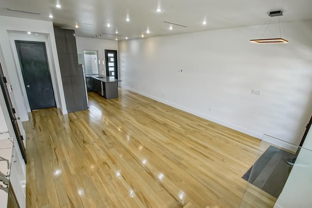 4317 Anthony St, Metairie, LA 70001 - unfurnished living room featuring light wood-style flooring, a sink, and baseboards