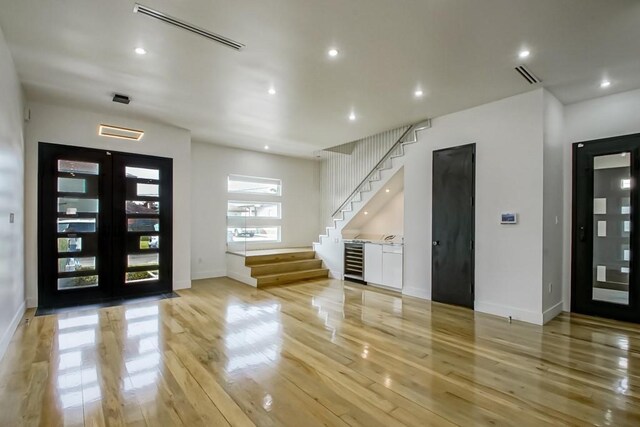 4317 Anthony St, Metairie, LA 70001 - foyer with stairs, light wood finished floors, baseboards, beverage cooler, and recessed lighting