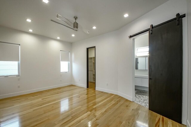 4317 Anthony St, Metairie, LA 70001 - unfurnished room featuring a barn door, light wood-style flooring, recessed lighting, healthy amount of natural light, and baseboards