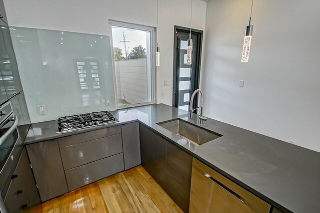4317 Anthony St, Metairie, LA 70001 - kitchen with a sink, stainless steel gas cooktop, light wood-style flooring, modern cabinets, and dark countertops