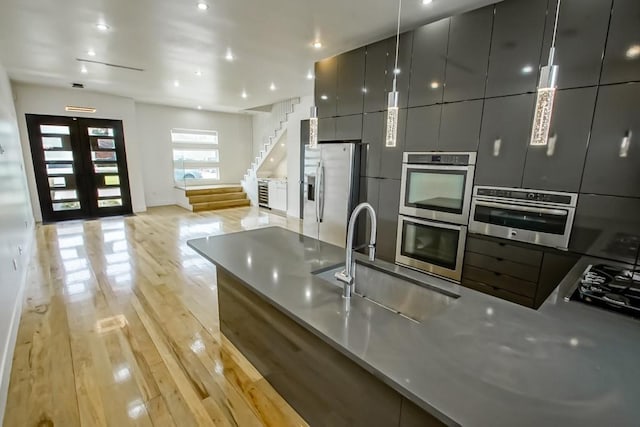4317 Anthony St, Metairie, LA 70001 - kitchen with a sink, stainless steel appliances, light wood-style floors, modern cabinets, and recessed lighting