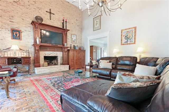 living room with a fireplace, a towering ceiling, and a chandelier