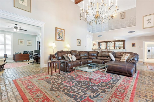 living room featuring ceiling fan with notable chandelier, a high ceiling, and ornamental molding