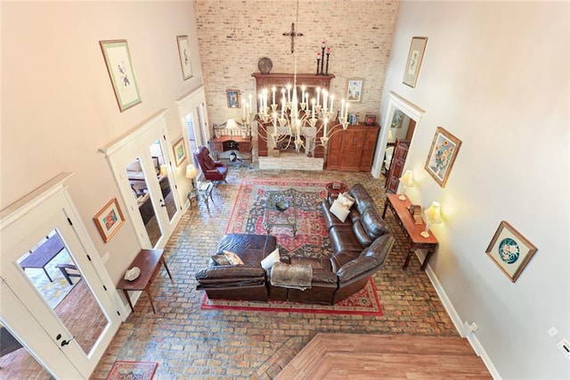 living room featuring hardwood / wood-style flooring, a towering ceiling, and a chandelier