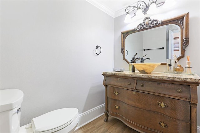 bathroom featuring ornamental molding, hardwood / wood-style floors, vanity, and toilet