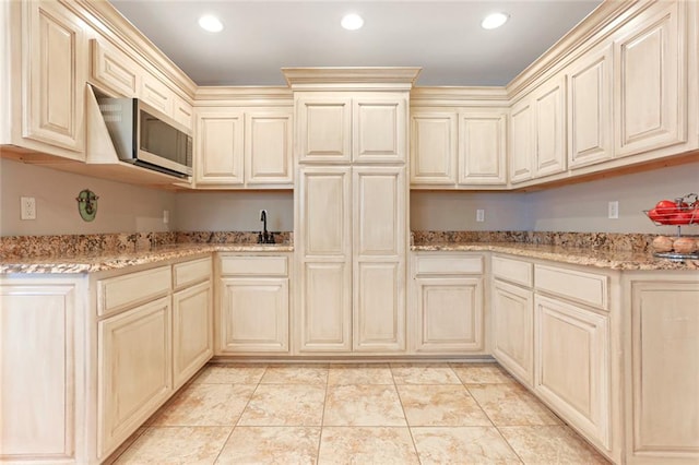 kitchen featuring cream cabinets and light stone counters