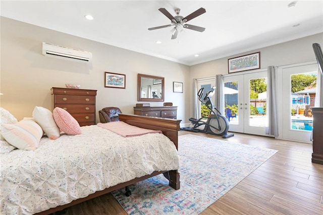 bedroom with access to outside, ceiling fan, french doors, light wood-type flooring, and a wall mounted air conditioner