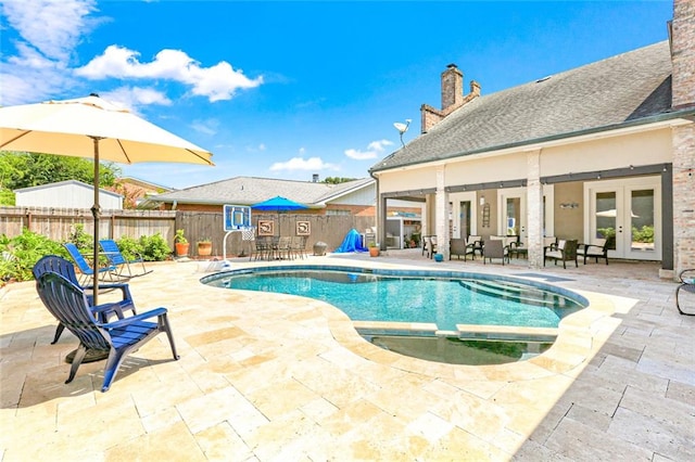 view of swimming pool with french doors, an in ground hot tub, and a patio