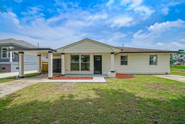 view of front of home featuring an attached carport, concrete driveway, and a front yard