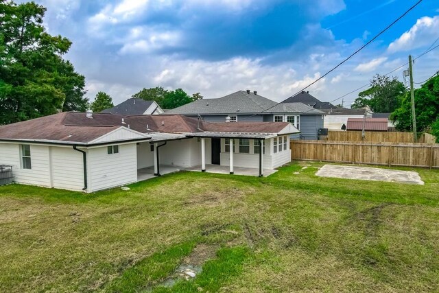 back of property featuring a patio area and a yard