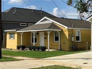 view of front facade with stucco siding, driveway, and a front yard