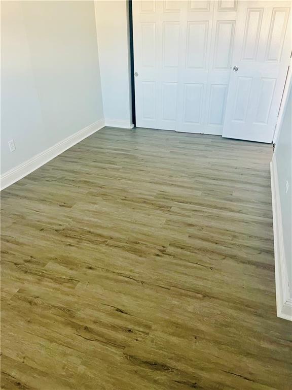 unfurnished bedroom with dark hardwood / wood-style flooring and a closet