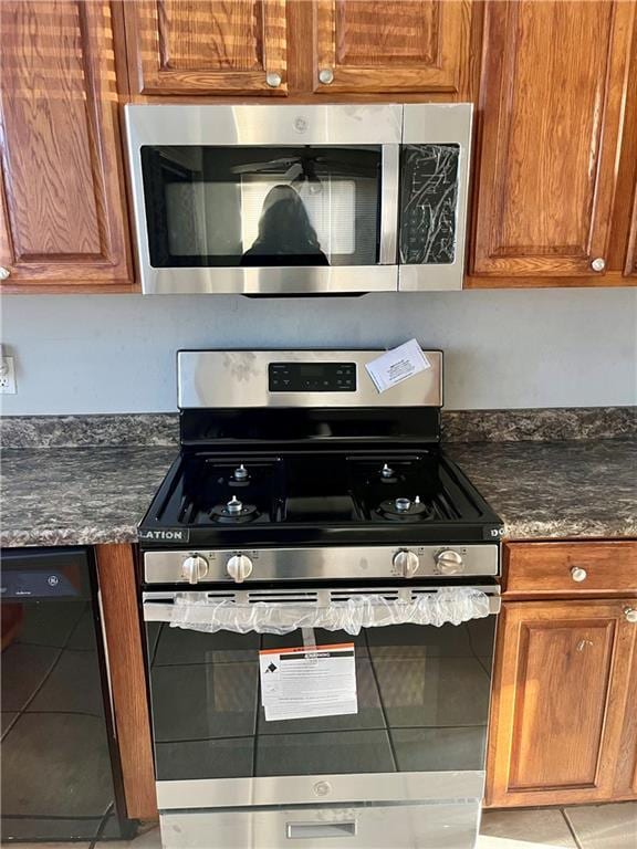 kitchen with dark stone counters and appliances with stainless steel finishes