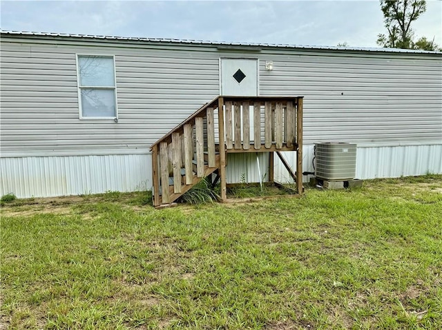 rear view of house featuring central AC, a deck, and a yard