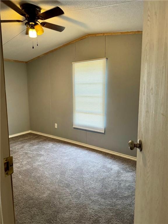 empty room with carpet floors, a textured ceiling, ceiling fan, and vaulted ceiling