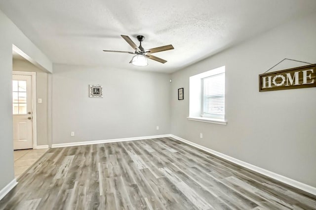 spare room with a textured ceiling, ceiling fan, and wood-type flooring