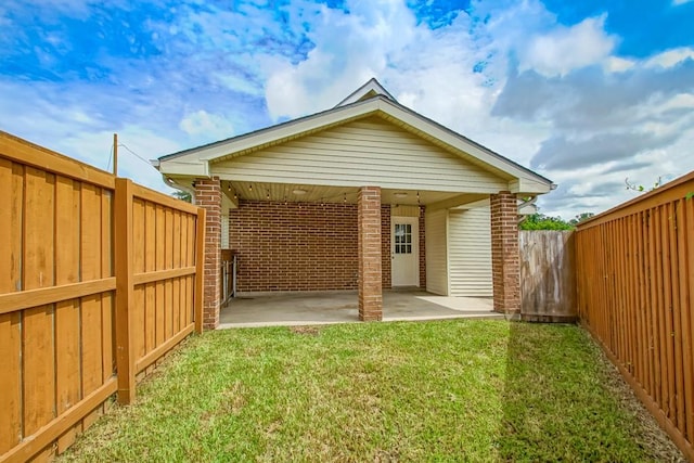 rear view of property featuring a patio and a lawn