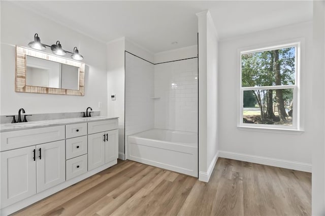 bathroom featuring tiled shower / bath, hardwood / wood-style floors, and dual bowl vanity