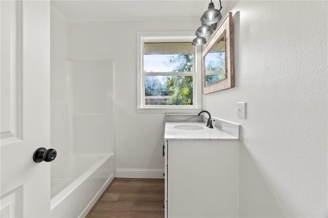 bathroom with hardwood / wood-style flooring, bathtub / shower combination, and vanity