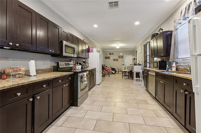 kitchen featuring light tile patterned floors, appliances with stainless steel finishes, sink, and light stone countertops